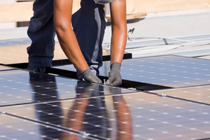 Green Energy - Man installing solar panels.